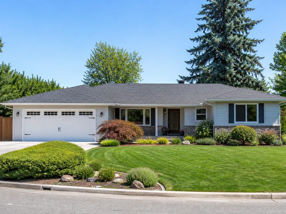 After photo: same home with fresh slate-gray shingles and tidy landscaping
